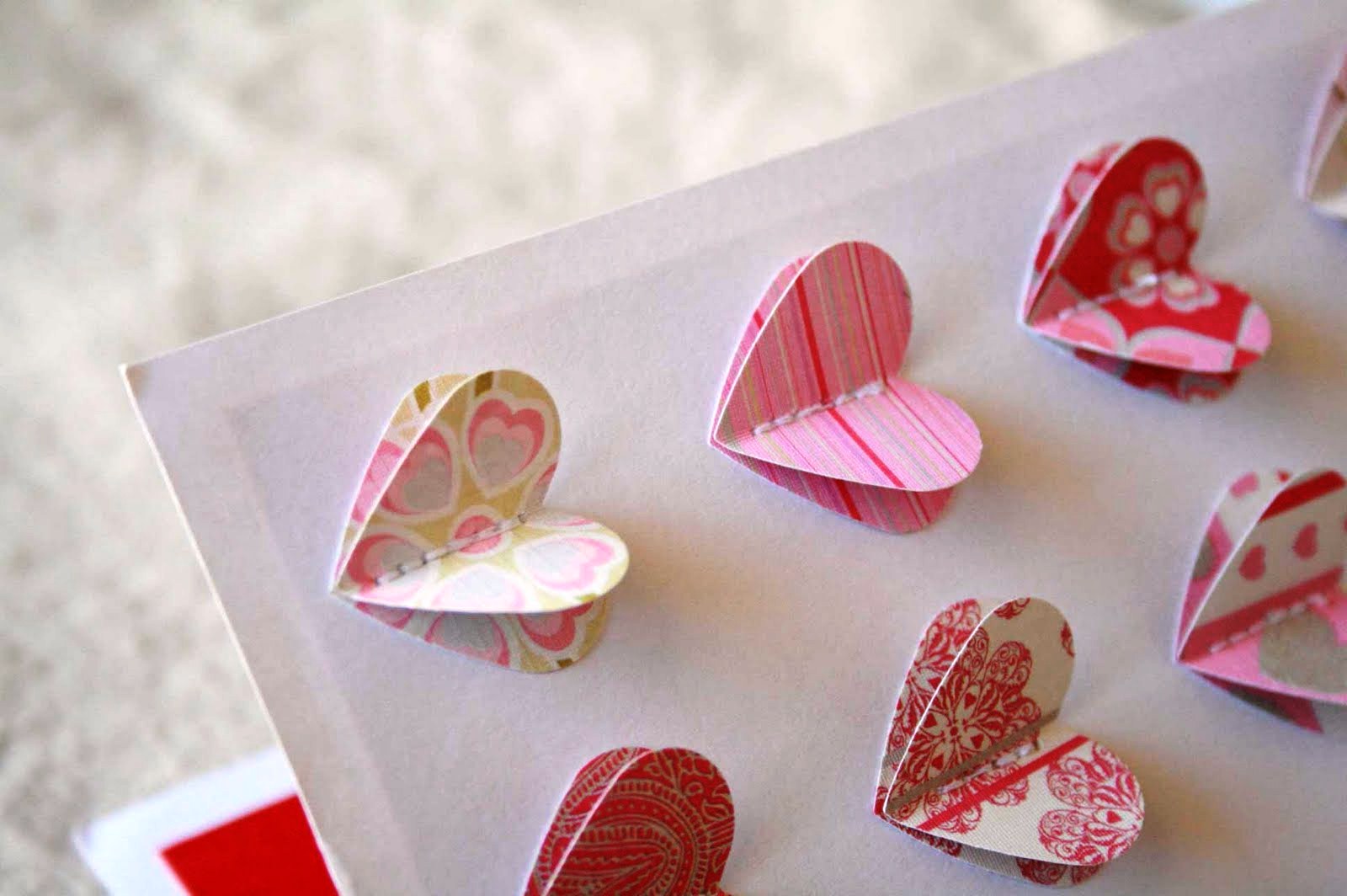 Ви можете вирізати однакові сердечка і закріпити з клеєм або нитками на листівці з щільного картону